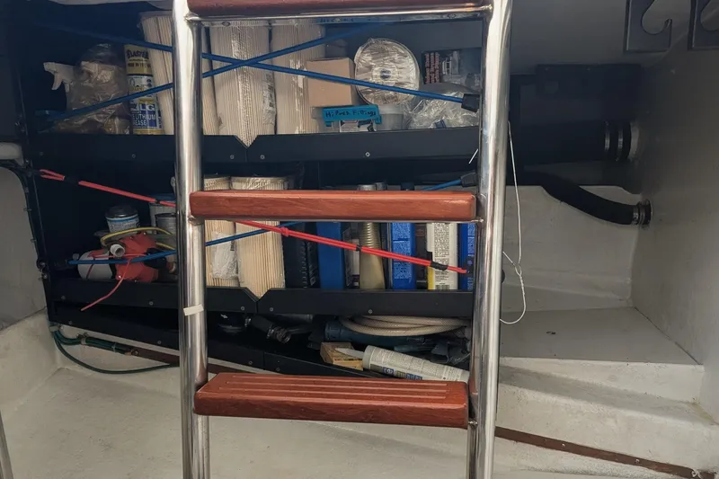 Slide: The Image of 2005 Kadey-Krogen Pilothouse storage area with ladder and maintenance supplies. - 69