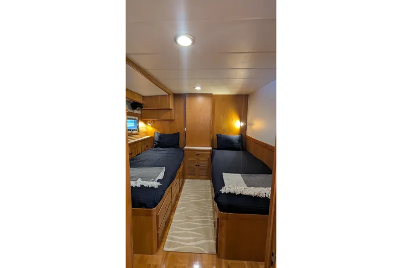 Slide: The Image of 2005 Kadey-Krogen Pilothouse cabin with twin beds, wooden interior, and cozy lighting. - 70