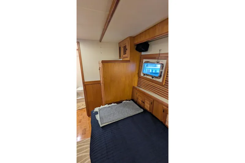 Slide: The Image of 2005 Kadey-Krogen Pilothouse interior with wood paneling and cozy bedding. - 71