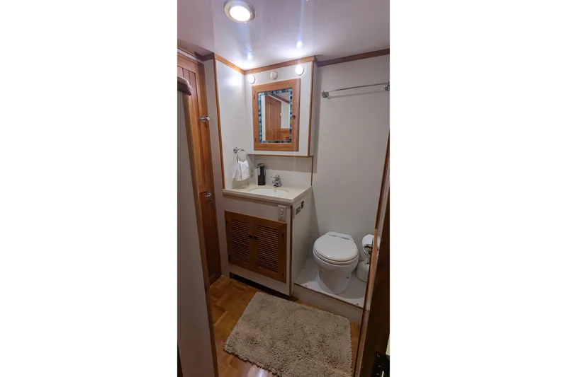 Slide: The Image of 2005 Kadey-Krogen Pilothouse bathroom with wooden accents, mirror, and toilet. - 73