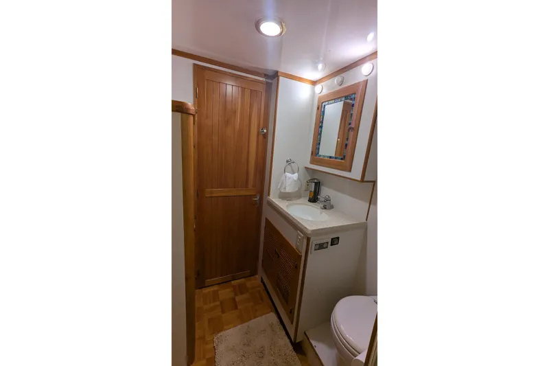 Slide: The Image of 2005 Kadey-Krogen Pilothouse bathroom with wooden door, sink, and mirror. - 75