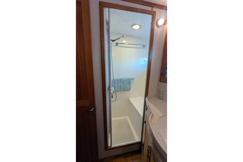 Slide: The Image of Shower area in 2005 Kadey-Krogen Pilothouse, featuring glass door and towel rack. - 76