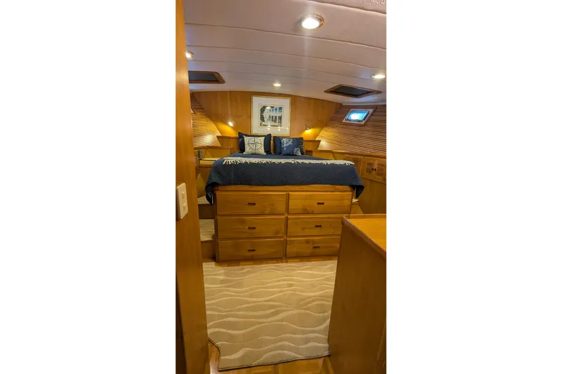 Slide: The Image of 2005 Kadey-Krogen Pilothouse bedroom with wooden interior and cozy bedding. - 80