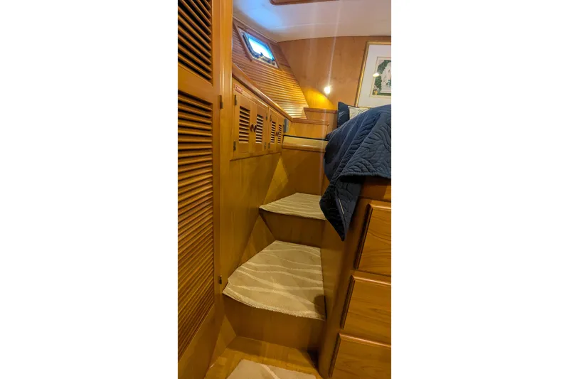 Slide: The Image of 2005 Kadey-Krogen Pilothouse interior with wooden stairs and cozy cabin decor. - 86
