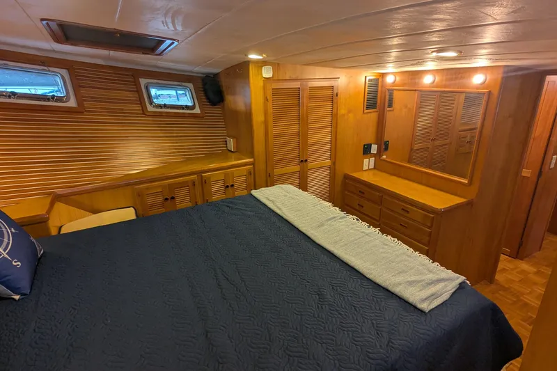 Slide: The Image of Luxurious 2005 Kadey-Krogen Pilothouse bedroom with wood paneling and cozy bedding. - 87