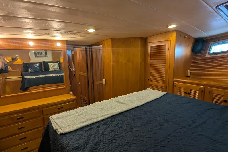 Slide: The Image of Luxurious 2005 Kadey-Krogen Pilothouse bedroom with wooden interior and cozy bedding. - 88