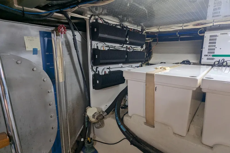 Slide: The Image of Engine room of a 2005 Kadey-Krogen Pilothouse with electrical components and storage boxes. - 95