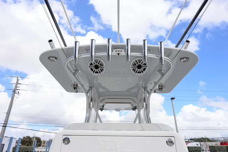 Slide: The Image of 2021 SeaVee 322Z boat with rod holders and speakers under a clear blue sky. - 11