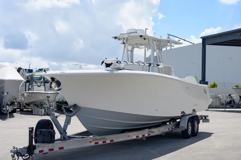 Slide: The Image of 2021 SeaVee 322Z boat on trailer, parked outdoors under a cloudy sky. - 4