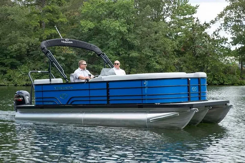 The Image of 2026 Veranda Vista22RC pontoon boat cruising on a serene lake with lush greenery. - 1