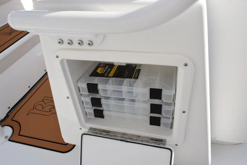 Slide: The Image of Storage compartment on a 2026 BlackJack 256 Coastal boat with organized tackle boxes. - 17