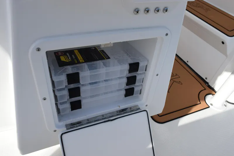 Slide: The Image of Storage compartment on 2026 BlackJack 256 Coastal boat with organized tackle boxes. - 18