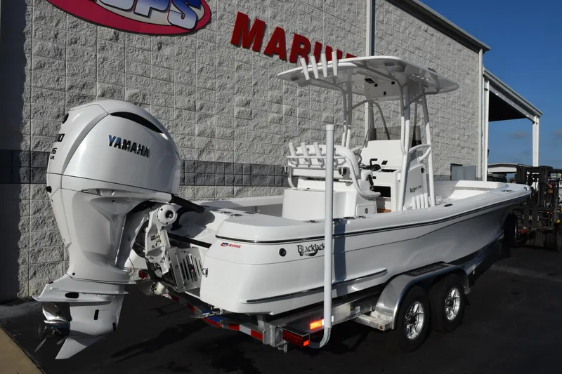 Slide: The Image of 2026 BlackJack 256 Coastal boat with Yamaha engine on trailer outside marine store. - 4