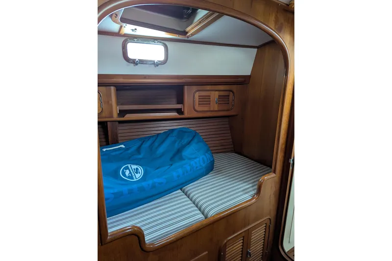 Slide: The Image of Cozy cabin interior of 1994 Passport Royal Passport 44 yacht with wooden finish and blue bedding. - 24