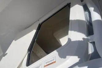 Slide: The Image of 2023 Trophy T24 CC boat interior detail with open hatch and sunlight shadows. - 11