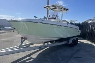 Slide: The Image of 2023 Trophy T24 CC boat on trailer, parked outdoors under clear sky. - 4