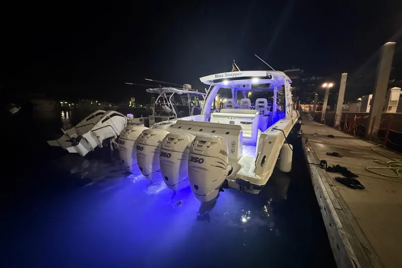 The Image of 2017 Boston Whaler 420 Outrage boat docked at night with blue underwater lights. - 0