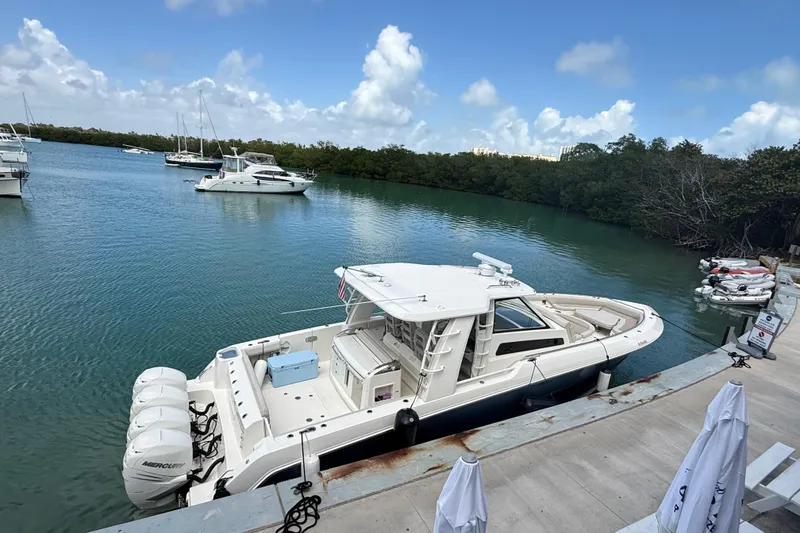 Slide: The Image of 2017 Boston Whaler 420 Outrage docked in a serene marina setting. - 15