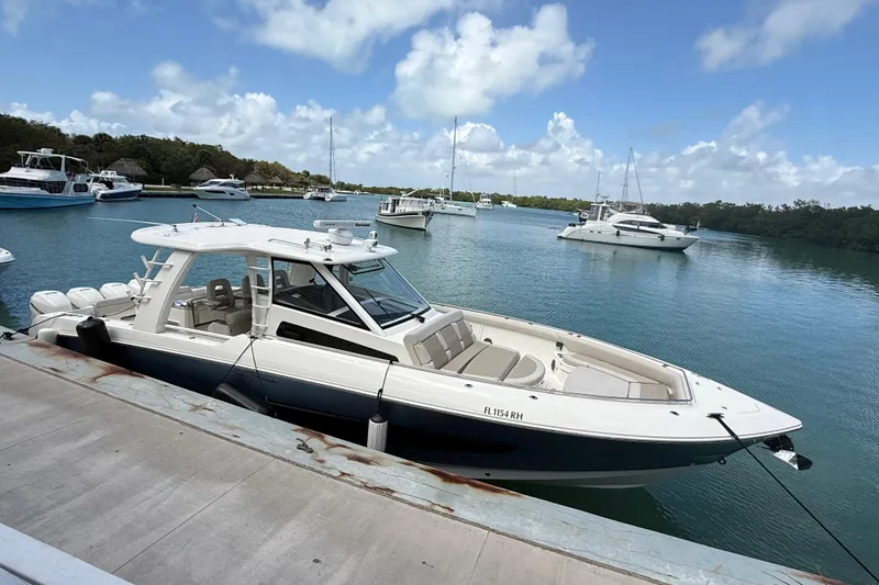 Slide: The Image of 2017 Boston Whaler 420 Outrage docked in a serene marina setting. - 16