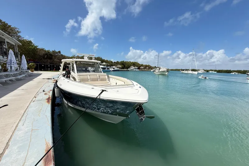 Slide: The Image of 2017 Boston Whaler 420 Outrage docked in a serene marina under a clear blue sky. - 19