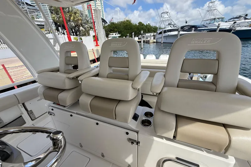 Slide: The Image of 2017 Boston Whaler 420 Outrage helm seats, luxurious design, docked at marina. - 20