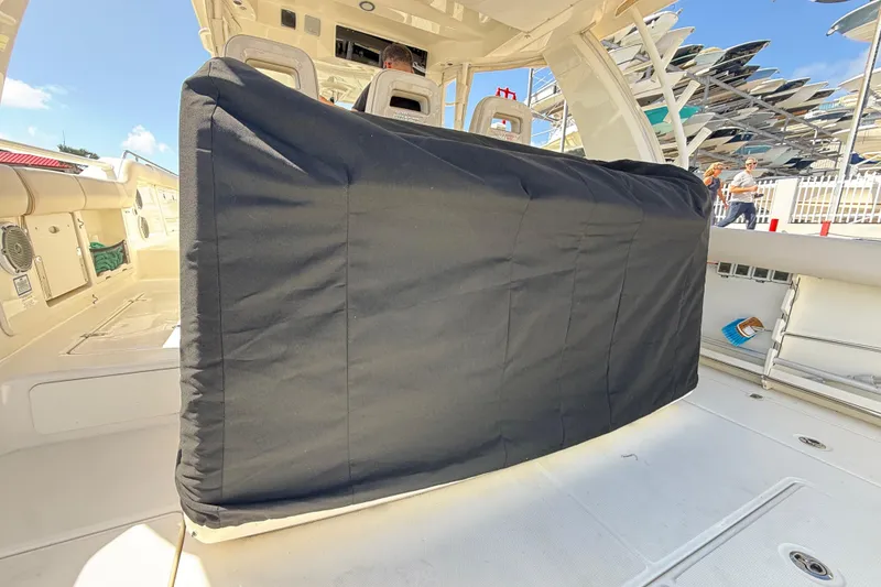 Slide: The Image of 2017 Boston Whaler 420 Outrage interior with covered console, docked under clear sky. - 27