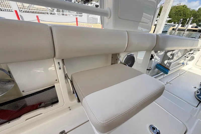 Slide: The Image of 2017 Boston Whaler 420 Outrage boat interior with beige seating and storage compartments. - 30
