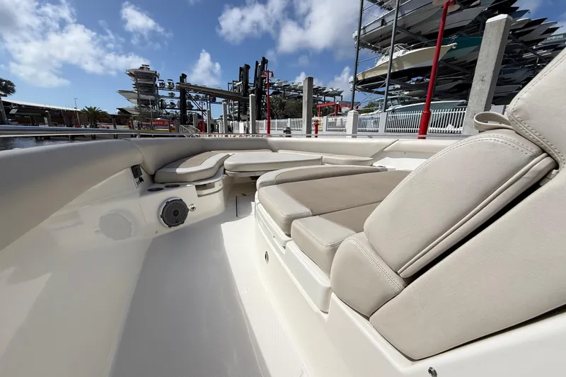 Slide: The Image of 2017 Boston Whaler 420 Outrage interior with cushioned seating and speaker, docked under blue sky. - 38