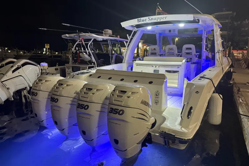 Slide: The Image of 2017 Boston Whaler 420 Outrage boat with illuminated deck and four Mercury 350 engines at night. - 4