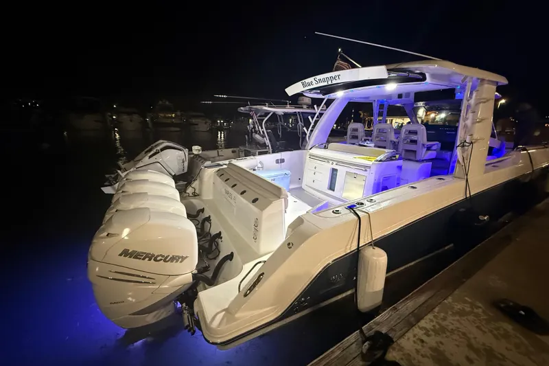 Slide: The Image of 2017 Boston Whaler 420 Outrage boat docked at night with blue interior lighting. - 5