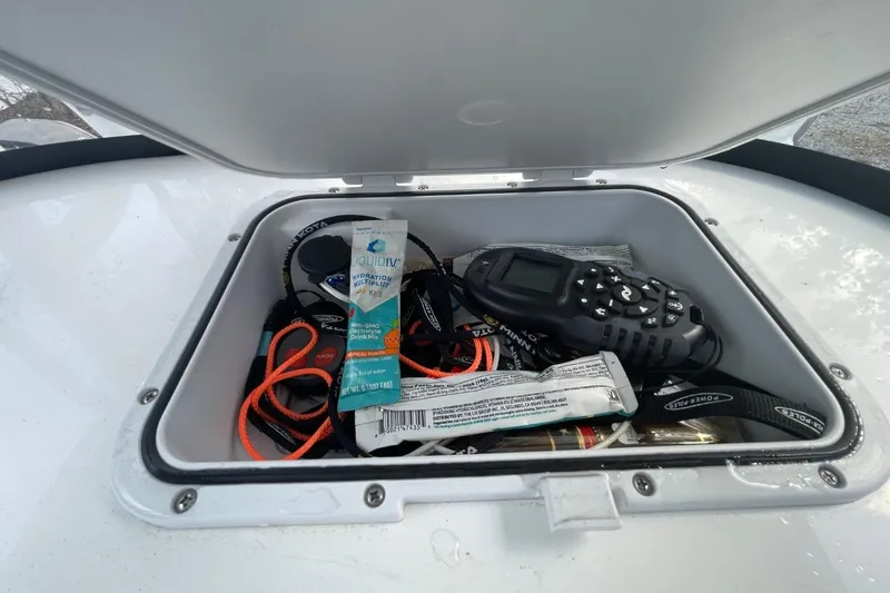 Slide: The Image of Open storage compartment on 2023 Sea Pro 248 Bay boat with gear and hydration mix. - 19