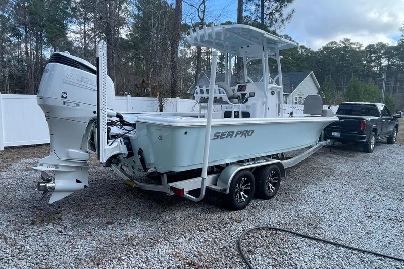 Slide: The Image of 2023 Sea Pro 248 Bay boat on trailer, parked outdoors with truck. - 3
