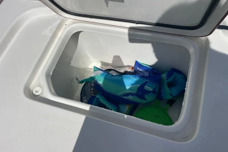 Slide: The Image of Open storage compartment on 2023 Sea Pro 248 Bay boat with various items inside. - 32
