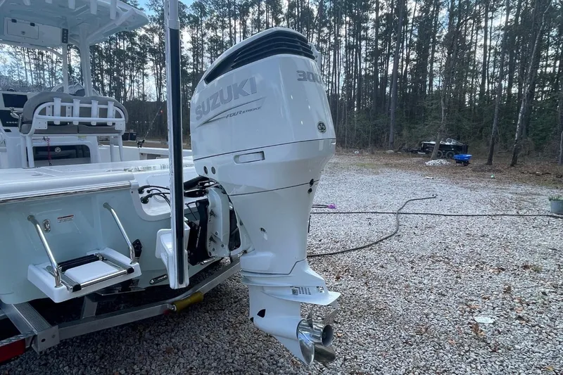 Slide: The Image of 2023 Sea Pro 248 Bay boat with Suzuki outboard motor in a wooded area. - 6