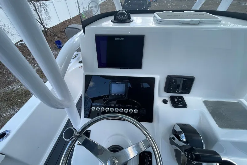 Slide: The Image of 2023 Sea Pro 248 Bay boat dashboard with steering wheel and electronic controls. - 8