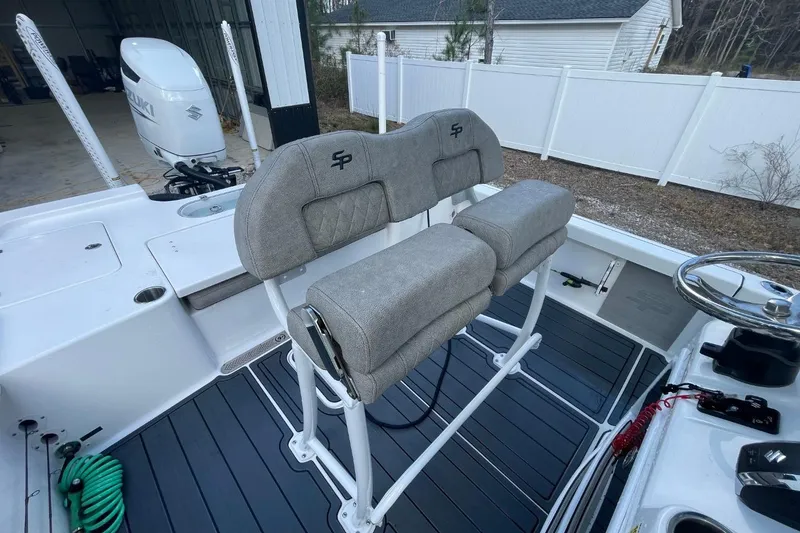 Slide: The Image of 2023 Sea Pro 248 Bay boat interior with dual seats and Suzuki outboard motor. - 9