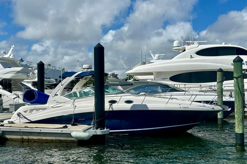 The Image of 2008 Sea Ray 340 Sundancer yacht docked at marina under cloudy sky. - 0