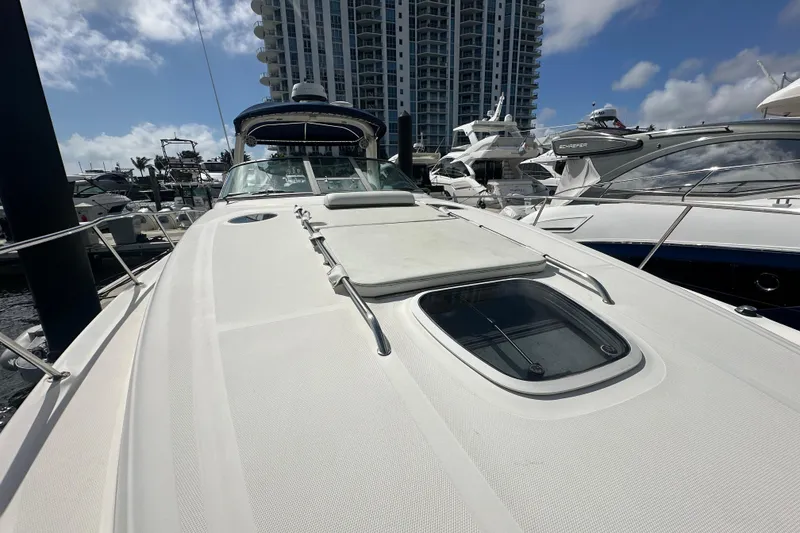 Slide: The Image of 2008 Sea Ray 340 Sundancer yacht docked at marina with modern buildings in background. - 16