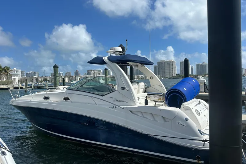 Slide: The Image of 2008 Sea Ray 340 Sundancer docked at marina with city skyline in background. - 2