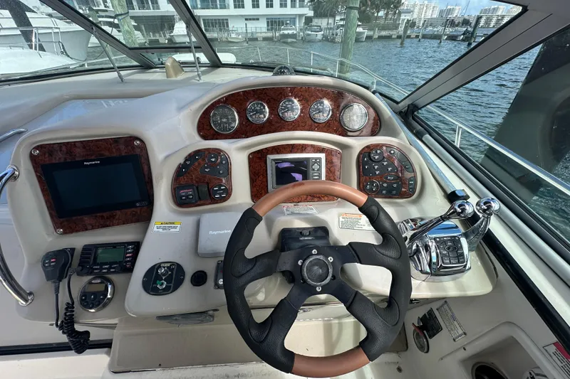 Slide: The Image of 2008 Sea Ray 340 Sundancer helm with steering wheel, gauges, and navigation controls. - 34
