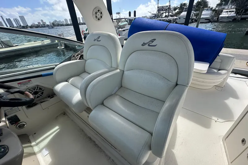 Slide: The Image of 2008 Sea Ray 340 Sundancer cockpit with white leather seats, overlooking marina. - 42