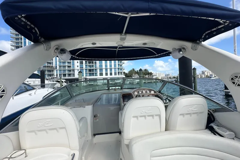 Slide: The Image of 2008 Sea Ray 340 Sundancer boat interior with helm, docked near waterfront buildings. - 44