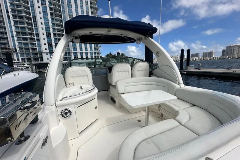 Slide: The Image of 2008 Sea Ray 340 Sundancer yacht with spacious seating, docked near modern buildings. - 46