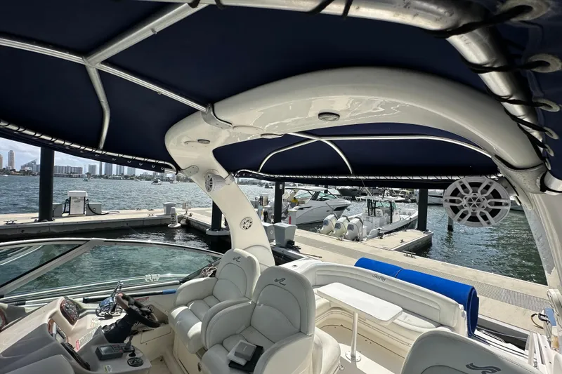 Slide: The Image of 2008 Sea Ray 340 Sundancer yacht interior with marina view, featuring seating and canopy. - 50