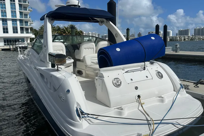 Slide: The Image of 2008 Sea Ray 340 Sundancer docked at marina, featuring spacious seating and blue accessories. - 6
