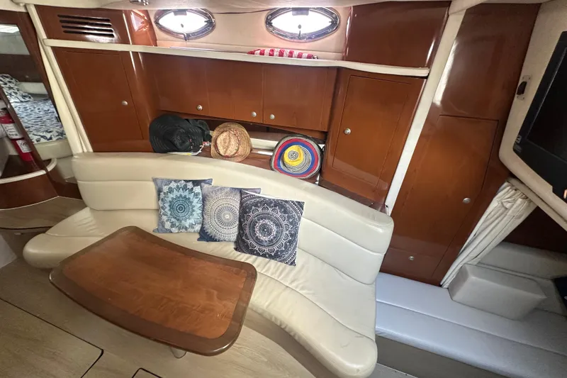 Slide: The Image of 2008 Sea Ray 340 Sundancer cabin with curved seating, wooden table, and decorative pillows. - 60