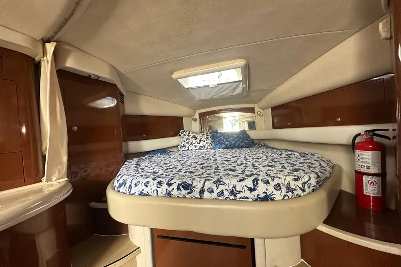Slide: The Image of 2008 Sea Ray 340 Sundancer cabin with bed, wood cabinets, and fire extinguisher. - 73