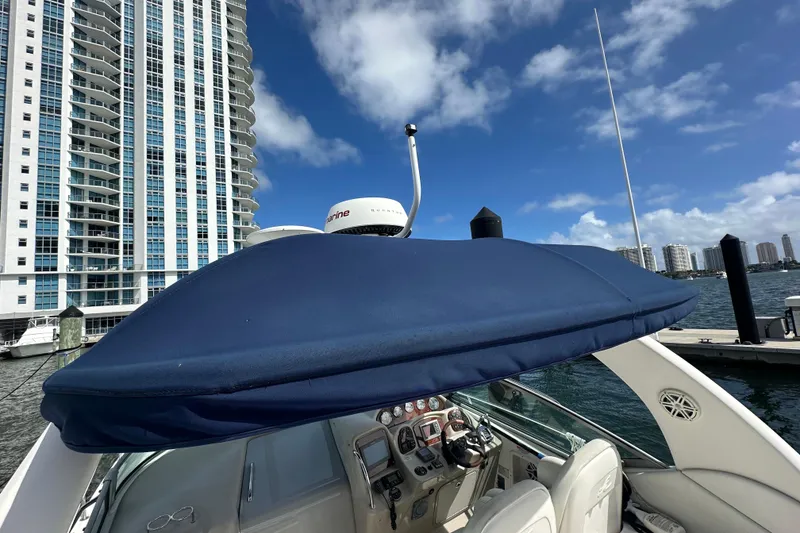 Slide: The Image of 2008 Sea Ray 340 Sundancer yacht docked near high-rise buildings under blue sky. - 75