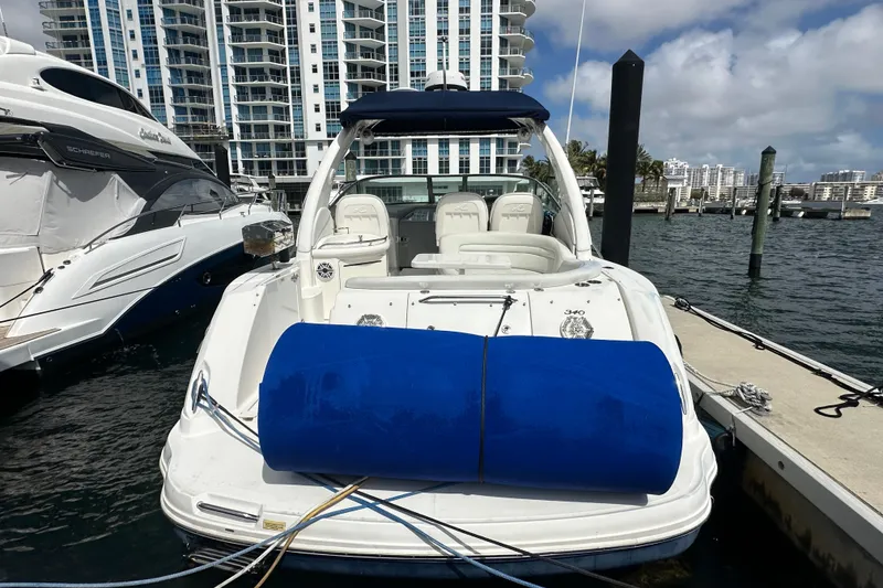 Slide: The Image of 2008 Sea Ray 340 Sundancer docked at marina with blue fender, cityscape background. - 8