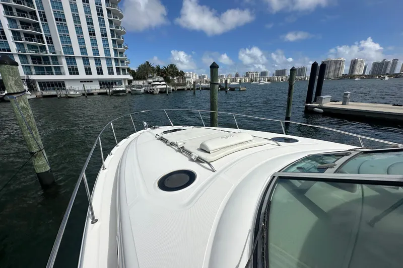 Slide: The Image of 2008 Sea Ray 340 Sundancer yacht docked near waterfront buildings under blue sky. - 9